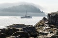 Fishing boat in morning fog heads out to sea Royalty Free Stock Photo