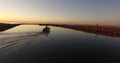 A fishing boat moving slowly during sunrise