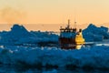 Fishing boat navigates glacier-filled waters at sunset Royalty Free Stock Photo