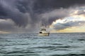 Fishing boat in open waters. Storm clouds over calm sea\'s with boat heading to shore Royalty Free Stock Photo