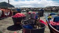 Fishing boat parked near pier, drift nets lying in baskets, small business