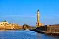 Fishing boat pass by famous Lighthouse and walls of old port, Firka fortress, Old Venetian harbour of Chania, Crete Royalty Free Stock Photo