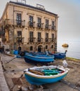 Fishing boat on the pavement in front of old building in small village in Calabria, Scilla, Italy Royalty Free Stock Photo