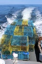 A fishing boat piled high with modern lobster traps on the open ocean off the coast of Nova Scotia. Royalty Free Stock Photo