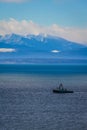 A fishing boat in Puget sound sailing in front of the Olympic Mountains Royalty Free Stock Photo