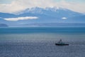 A fishing boat in Puget sound sailing in front of the Olympic Mountains