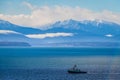 A fishing boat in Puget sound sailing in front of the Olympic Mountains Royalty Free Stock Photo