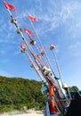 Fishing boat with red and white flags on a blue sky background. Royalty Free Stock Photo