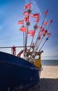 Fishing boat with red and white flags on a blue sky background Royalty Free Stock Photo