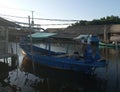 The fishing boat rests next to the riverside house in the evening. Tangerang Indonesia, July 14 2023.