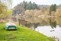 A fishing boat on the river shore surrounded by trees whiteout leaves spring day Royalty Free Stock Photo