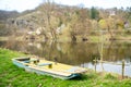 A fishing boat on the river shore surrounded by trees whiteout leaves spring day Royalty Free Stock Photo