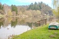 A fishing boat on the river shore surrounded by trees whiteout leaves spring day Royalty Free Stock Photo