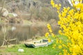 A fishing boat on the river shore surrounded by trees whiteout leaves spring day Royalty Free Stock Photo