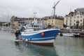 A fishing boat is sailing towards open sea in the harbour of dieppe, france in summer Royalty Free Stock Photo