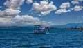 Fishing boat sails in waving sea, cloudy blue sky background Royalty Free Stock Photo