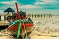 Fishing boat on sand beach near the bridge and sea. Relaxation on paradise tropical beach and resort concept. Garbage on beach