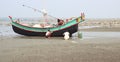 Fishing boat on sand with coral sea beach view .Fishermen are busy to fixed its problem before going into deep sea for fishing