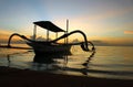 A Fishing Boat silhouette on a calm waves water and the sunrise morning light view background. Royalty Free Stock Photo