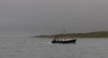 Fishing boat in the sea near the shore near woods in Cape Cod in Massachusetts Royalty Free Stock Photo