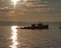 Fishing boat in sea at sunset