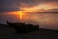 Fishing boat on the shore of the lake. Colorful sunrise on the sky Royalty Free Stock Photo