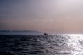 Fishing boat silhouette on the horizon with mountains in the background Royalty Free Stock Photo