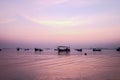 Fishing boat silhouette with orange sunrise sky and water reflection