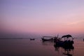 Fishing boat silhouette with orange sunrise sky and water reflection Royalty Free Stock Photo