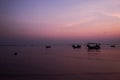 Fishing boat silhouette with orange sunrise sky and water reflection Royalty Free Stock Photo