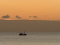 Fishing Boat at Sunset with Clouds and Gulls. Royalty Free Stock Photo