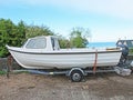 Fishing Boat white on a trailer concrete yard. fish Royalty Free Stock Photo