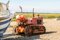 Fishing boats buoys and old rusty tractor on a pebble beach