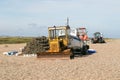 Fishing boats buoys and old rusty bulldozers tractor on a pebble beach