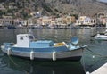 Fishing Boats and Colorful Greek Homes at Symi Port. July 14,2013 in Symi, Greece Royalty Free Stock Photo