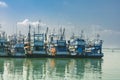 Fishing boats in a fishing village reflecting on the water.