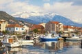 Fishing boats in harbor on background of snowy mountain peaks. Montenegro, Tivat city Royalty Free Stock Photo