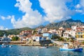 Fishing boats in Kokkari port with colourful Greek houses in background, Samos island, Greece Royalty Free Stock Photo