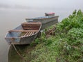 Foggy and  gloomy autumn scene of boats moored along riverbank. Royalty Free Stock Photo