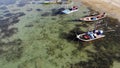 Fishing boats near shore. Various colorful fishing boats floating near coast on sea water in tropical country. Drone top view Royalty Free Stock Photo