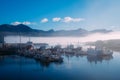 Fishing boats on a pier in blue fog in an early sunny morning in the summer Royalty Free Stock Photo