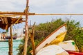 Fishing boats piled up at Yuctan Mexico marina byr rough wood shed with workers and buildings and truck visible across the water