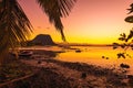 Fishing boats in a quiet ocean at sunset time. Le Morn mountain at Mauritius Royalty Free Stock Photo