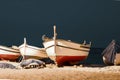 Fishing boats on a sandy beach in the evening against the background of the sea. Royalty Free Stock Photo