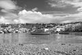 Fishing boats on sea beach in Mykonos, Greece. Sea village on cloudy sky. White houses on mountain landscape with nice