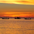 Fishing boats in sea at colorful sunset background