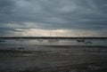 Fishing boats and small boats at low tide in UK on cloudy day