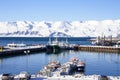 Fishing boats, snowy mountains, blue skies. Husavik harbour, Iceland on a cold winter morning