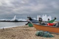 Fishing boats stranded on Aguda beach and Giant waves breaking on the breakwater Royalty Free Stock Photo