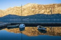 Fishing Boats On The Water In Small Harbor. Blue Sky And Mountains Reflected In The Sea. Montenegro, Kotor Bay